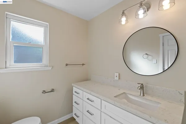 a bathroom with a sink mirror and toilet