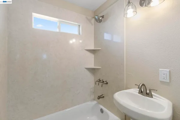 a bathroom with a sink a shower and a mirror