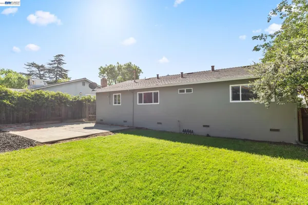 a backyard of a house with table and chairs