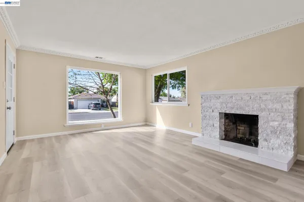a view of an empty room with window and fire place