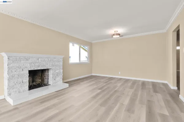 a view of empty room with fireplace and wooden floor