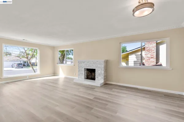 wooden floor fireplace and windows in an empty room