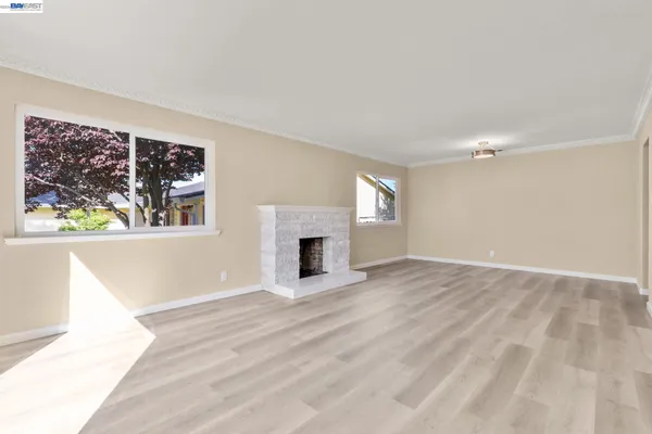a view of an empty room with a window and fireplace