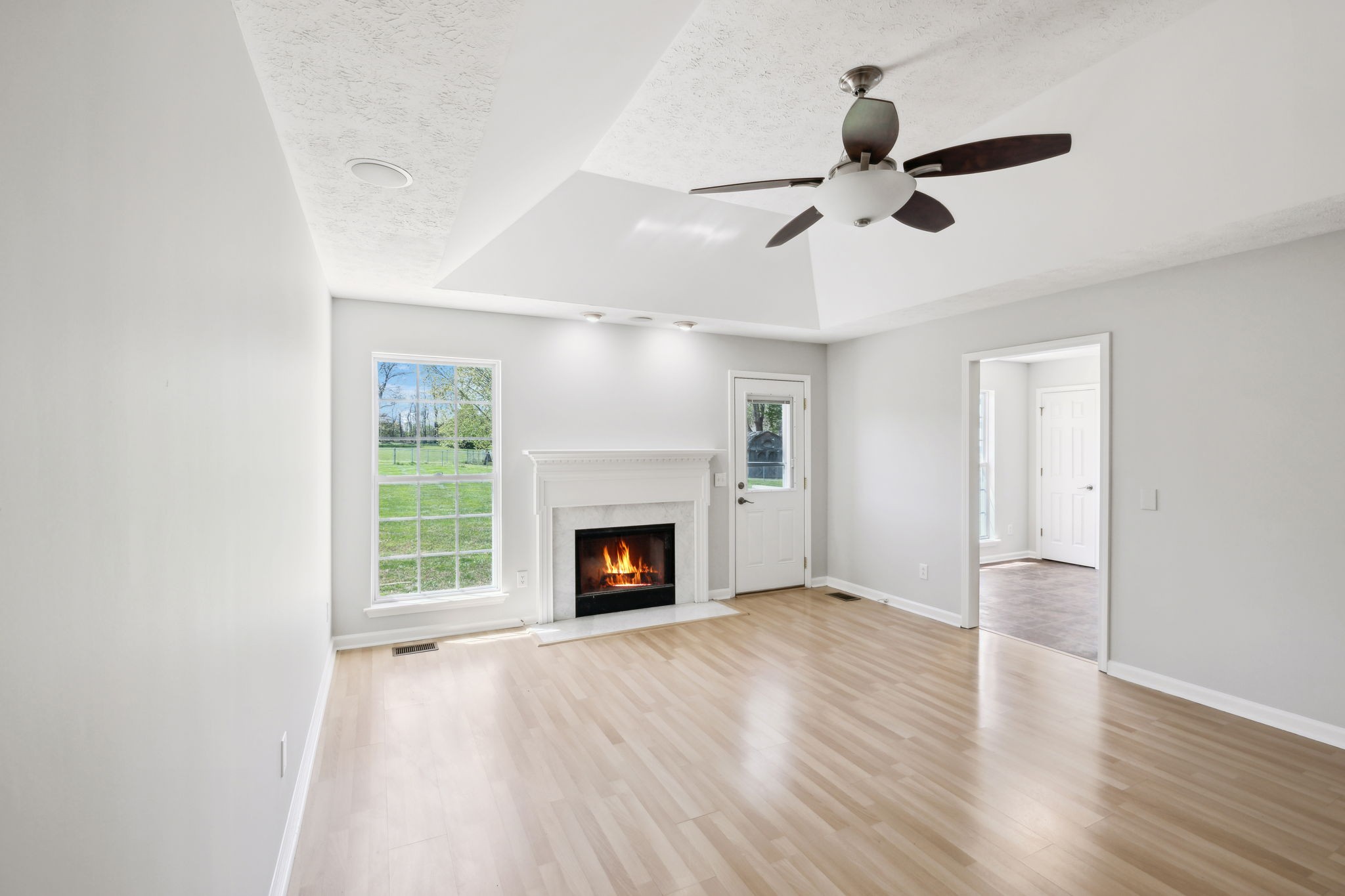 623 Audrey Road Mount Juliet, TN 37122 - Photo 6 of 27 an empty room with windows fireplace and a ceiling fan