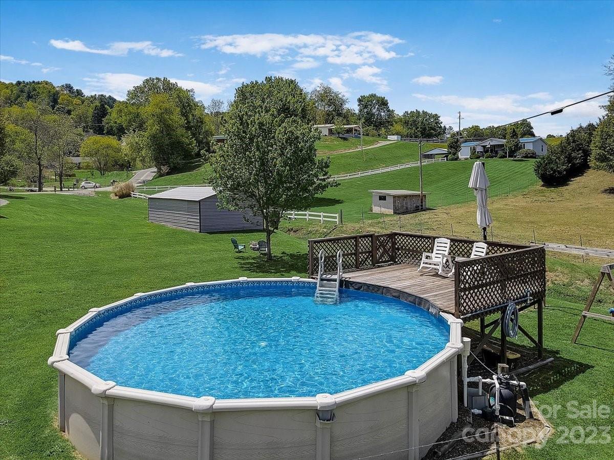 1393 Queentown Road Canton, NC 28716 - Photo 35 of 42 a view of a swimming pool with lawn chairs plants and large trees