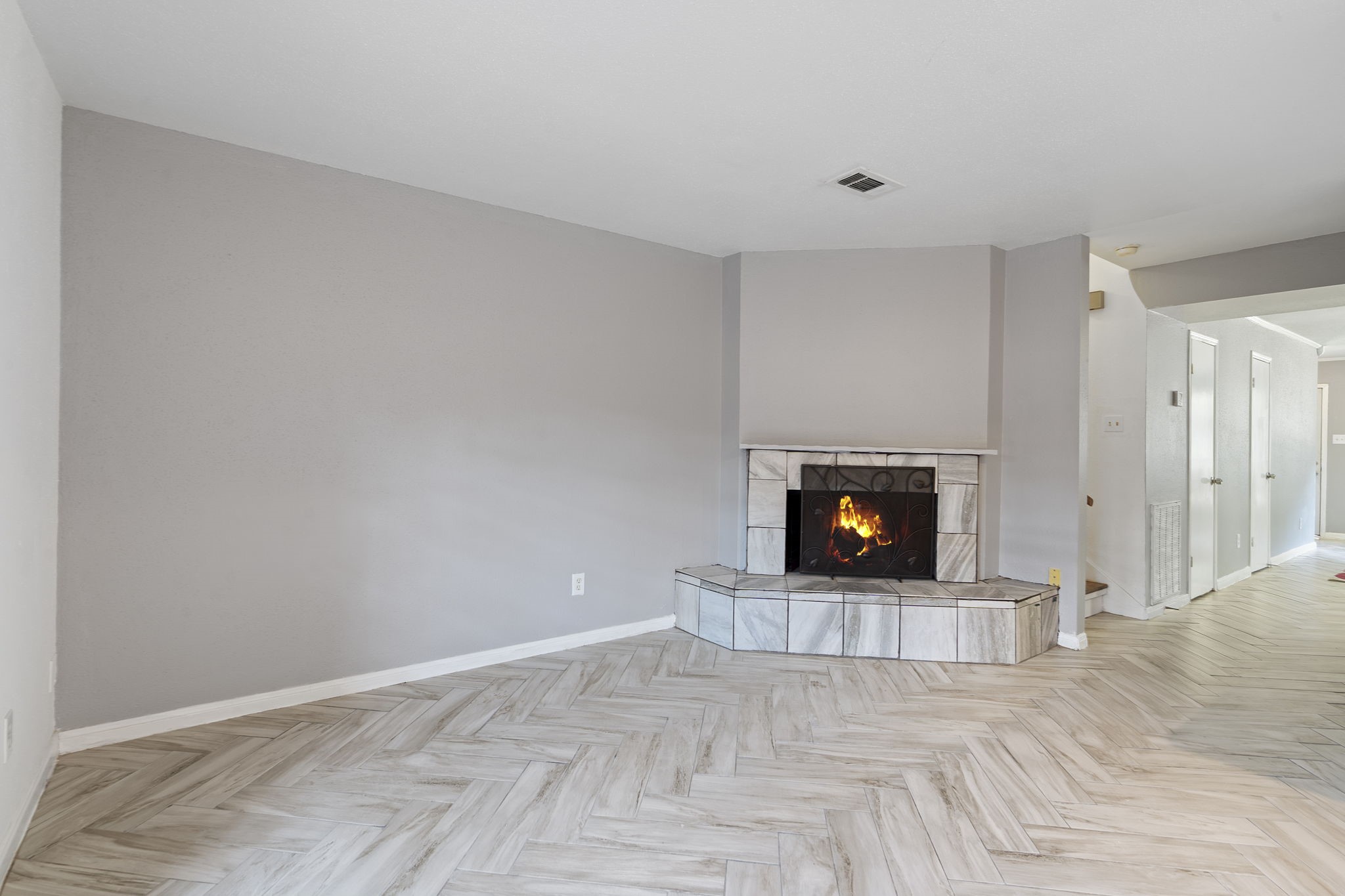 5801 Lumberdale Road, Unit 127 Houston, TX 77092 - Photo 12 of 26 a view of an empty room with wooden floor and a fireplace