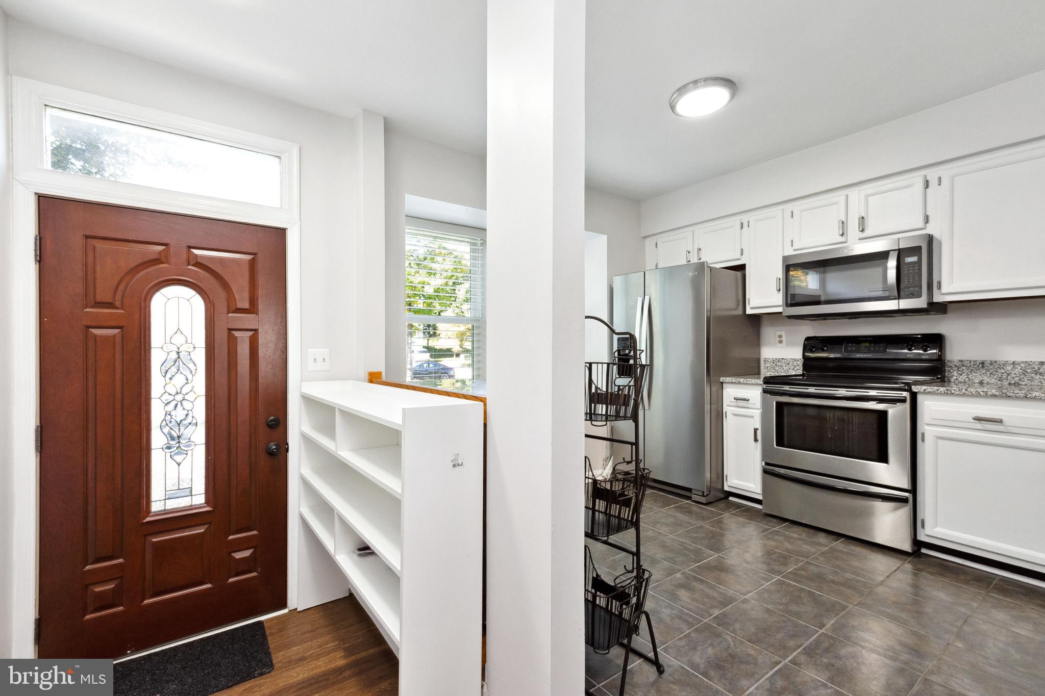 9525 Clocktower Lane Columbia, MD 21046 - Photo 3 of 19 a kitchen with stainless steel appliances white cabinets and a refrigerator