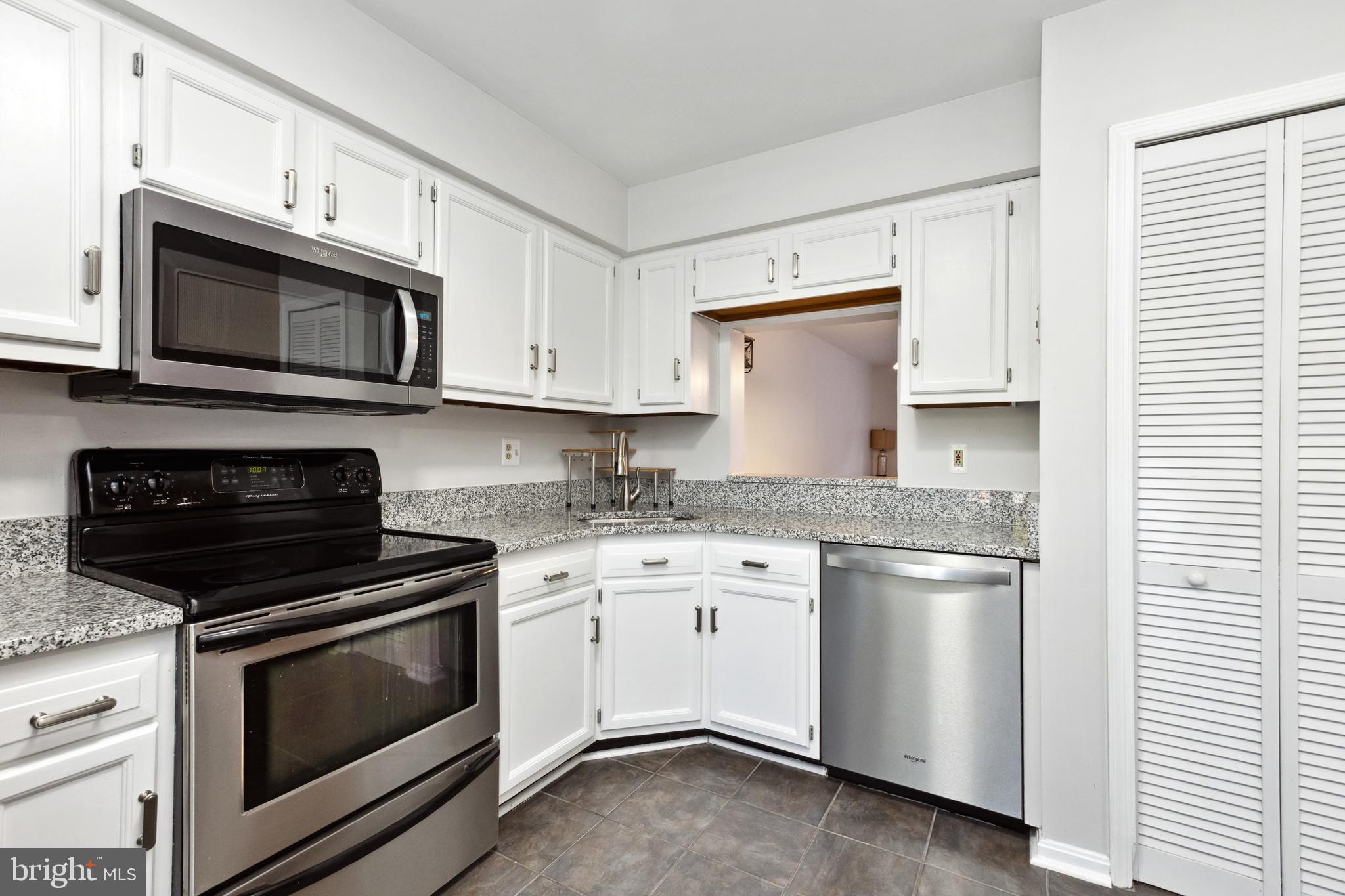 9525 Clocktower Lane Columbia, MD 21046 - Photo 5 of 19 a kitchen with granite countertop white cabinets and stainless steel appliances