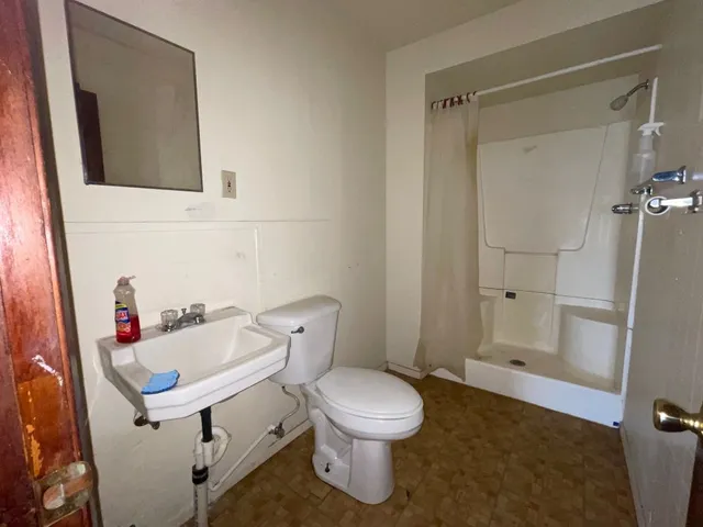 a bathroom with a sink a toilet and shower
