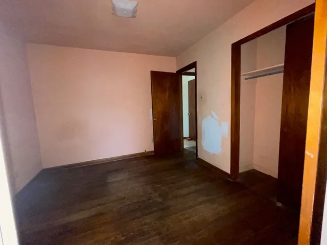 a view of an empty room with closet and a window