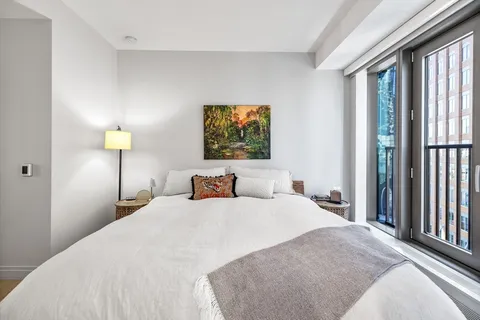 a bedroom with a bed and a painting on the wall