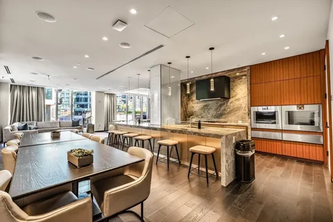 a room with stainless steel appliances lots of wooden furniture dining table and chairs