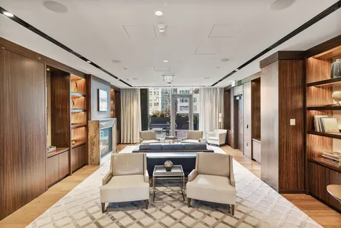 a living room with furniture fireplace and large window