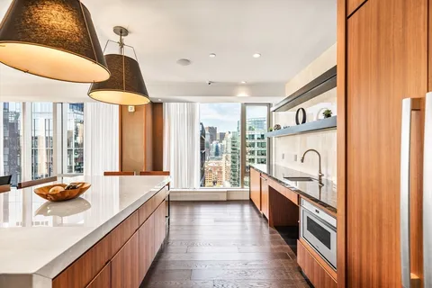 a large kitchen with stainless steel appliances granite countertop a large window and a sink