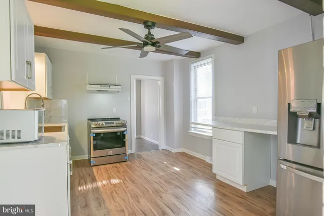 a open kitchen with a stove a sink and a refrigerator
