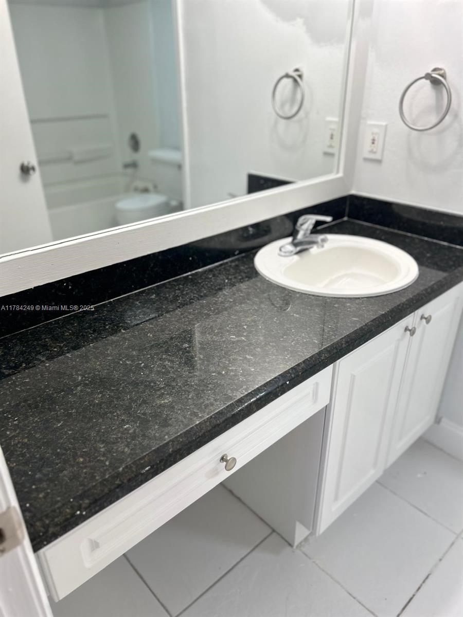 15201 Southwest 80th Street, Unit 302 Miami, FL 33193 - Photo 22 of 30 a bathroom with a sink and a mirror