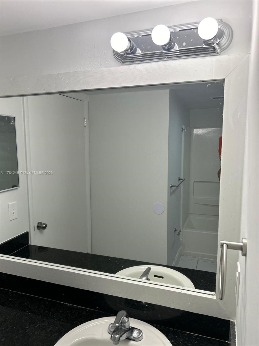 15201 Southwest 80th Street, Unit 302 Miami, FL 33193 - Photo 25 of 30 a bathroom with a sink and a mirror