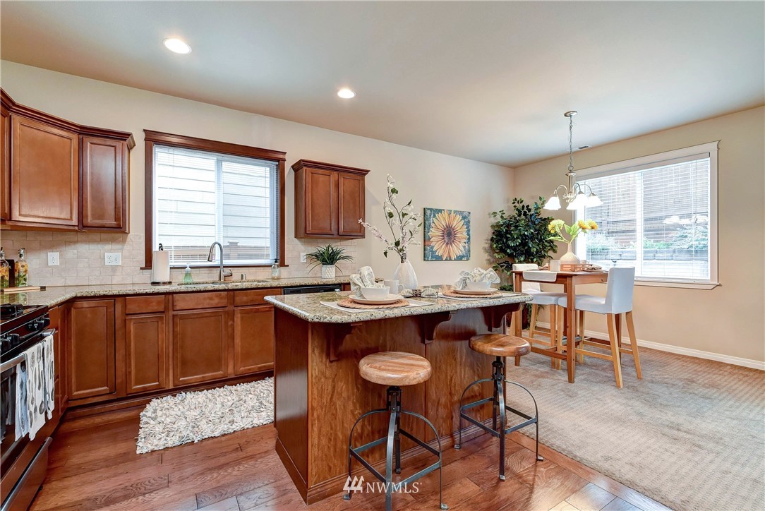 16220 2nd Avenue Southeast Bothell, WA 98012 - Photo 8 of 40 a kitchen with stainless steel appliances granite countertop a stove a sink dishwasher and cabinets with wooden floor