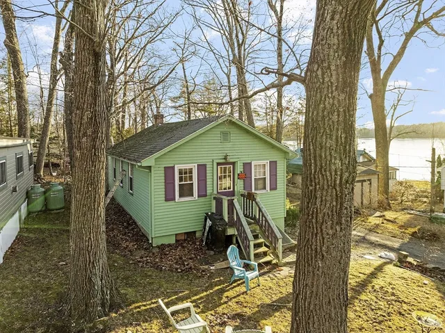 a view of a small house with trees in the background