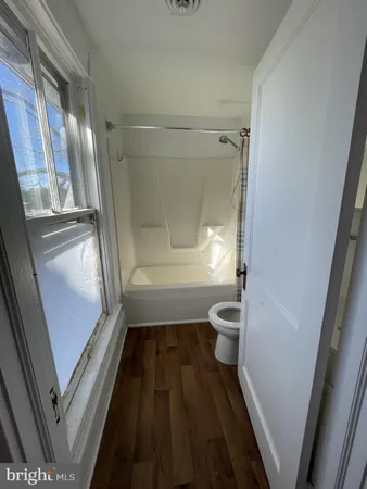 a bathroom with a granite countertop toilet a sink a mirror and a shower