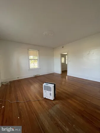 a view of a livingroom with wooden floor and window
