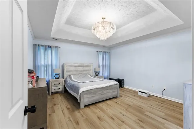 a spacious bedroom with a bed and a chandelier