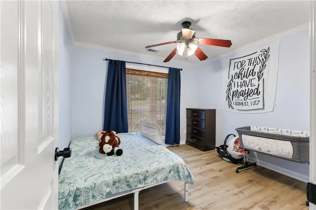 a bedroom with a bed and wooden floor