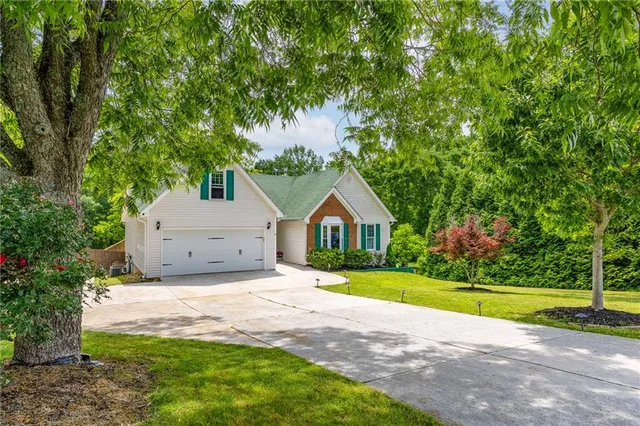 a view of a house with a big yard and large trees