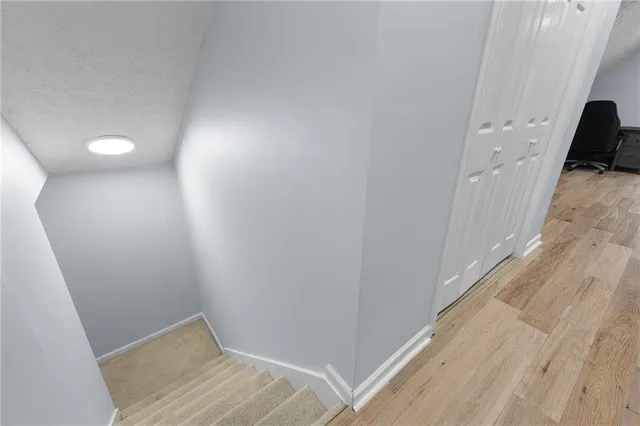 a view of hallway with stairs and a wooden floor