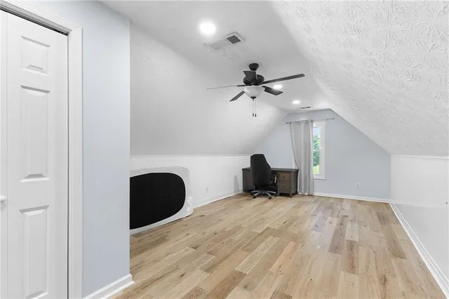 a view of a livingroom with a ceiling fan and wooden floor