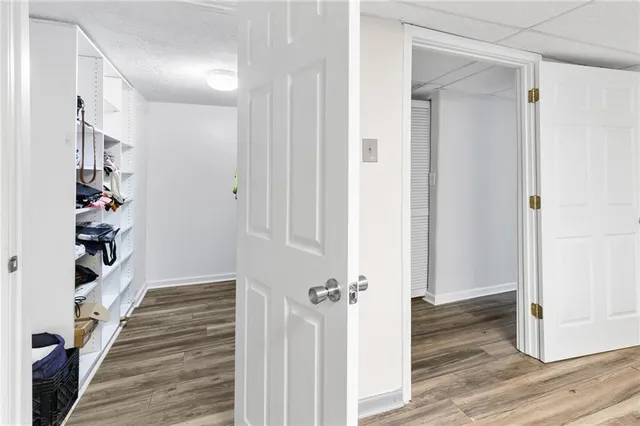 a view of a hallway with wooden floor and closet