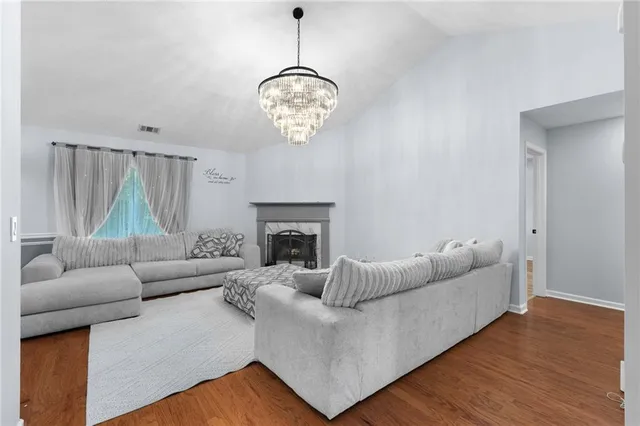 a living room with furniture a fireplace and a chandelier