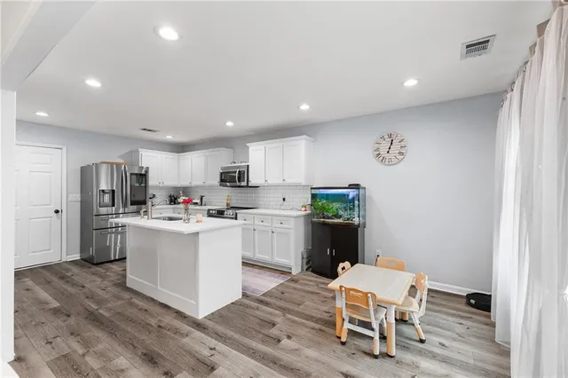 a kitchen with a sink cabinets and wooden floor