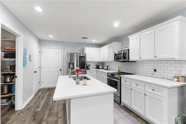 a kitchen with sink a microwave and cabinets