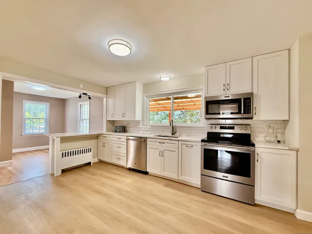 a kitchen with stainless steel appliances and white cabinets