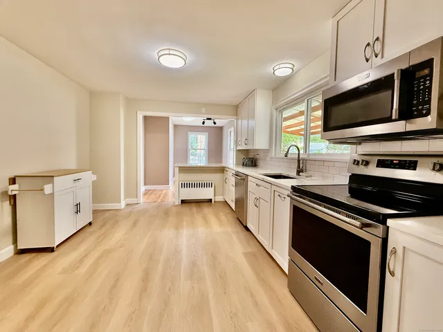 a kitchen with stainless steel appliances a stove microwave and sink