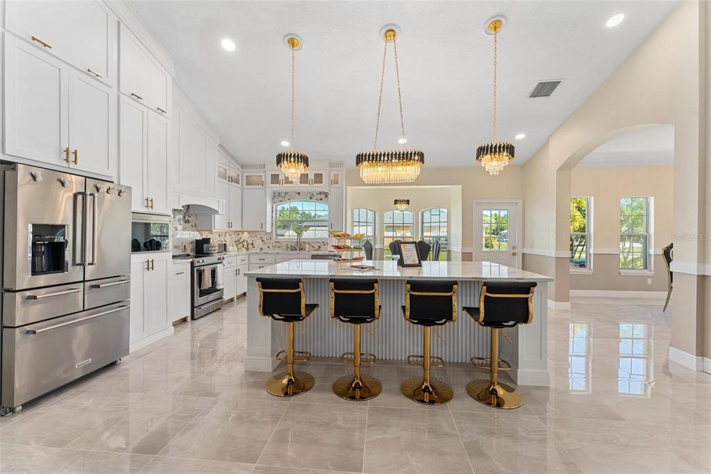 2832 Rodeo Drive Kissimmee, FL 34746 - Photo 11 of 46 a kitchen with stainless steel appliances kitchen island granite countertop a stove a sink and a refrigerator