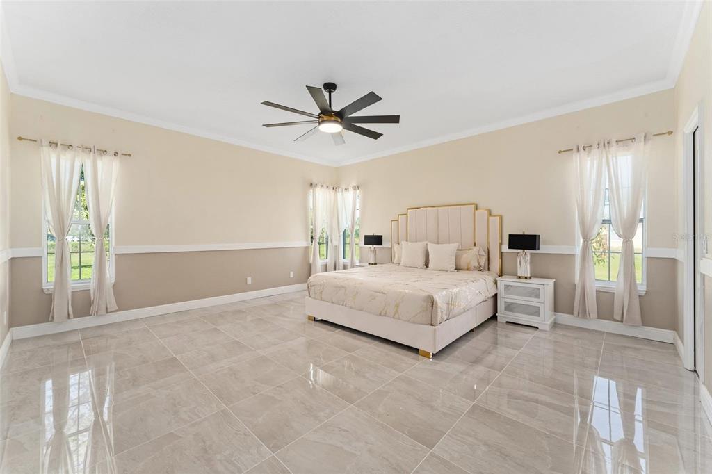 2832 Rodeo Drive Kissimmee, FL 34746 - Photo 23 of 46 a spacious bedroom with a large bed and a chandelier