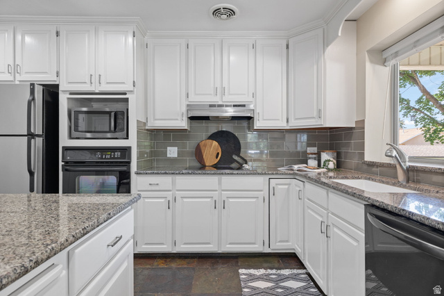 2370 Quail Run Circle East Sandy, UT 84093 - Photo 9 of 54 Kitchen featuring extensive white cabinetry, granite countertops, subway tile backsplash, built-in microwave, and stainless steel appliances
