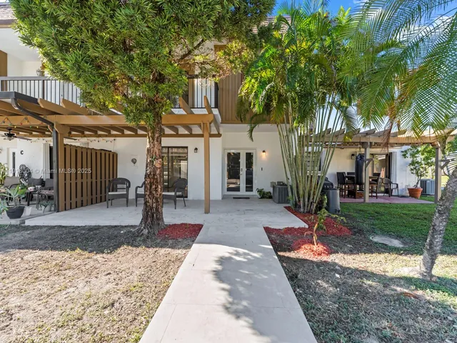 a view of a house with a yard and large tree