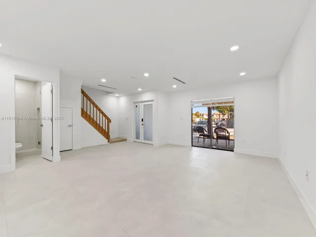 an empty room with windows and couches