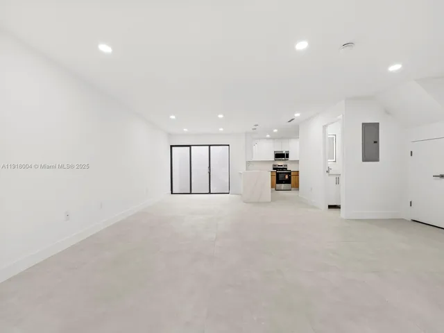 a view of an empty room with a kitchen