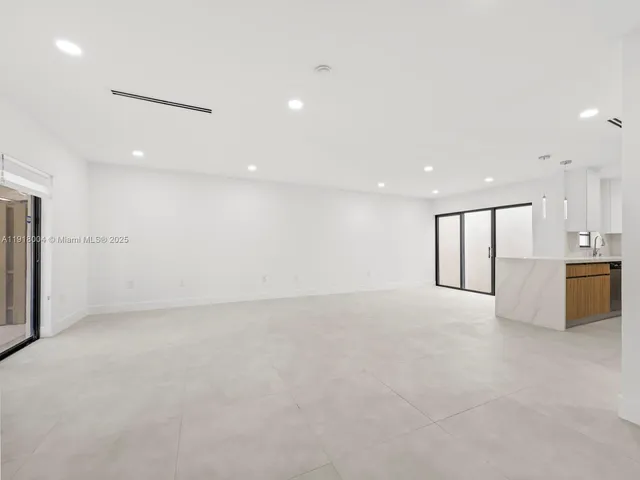 a view of an empty room with a kitchen