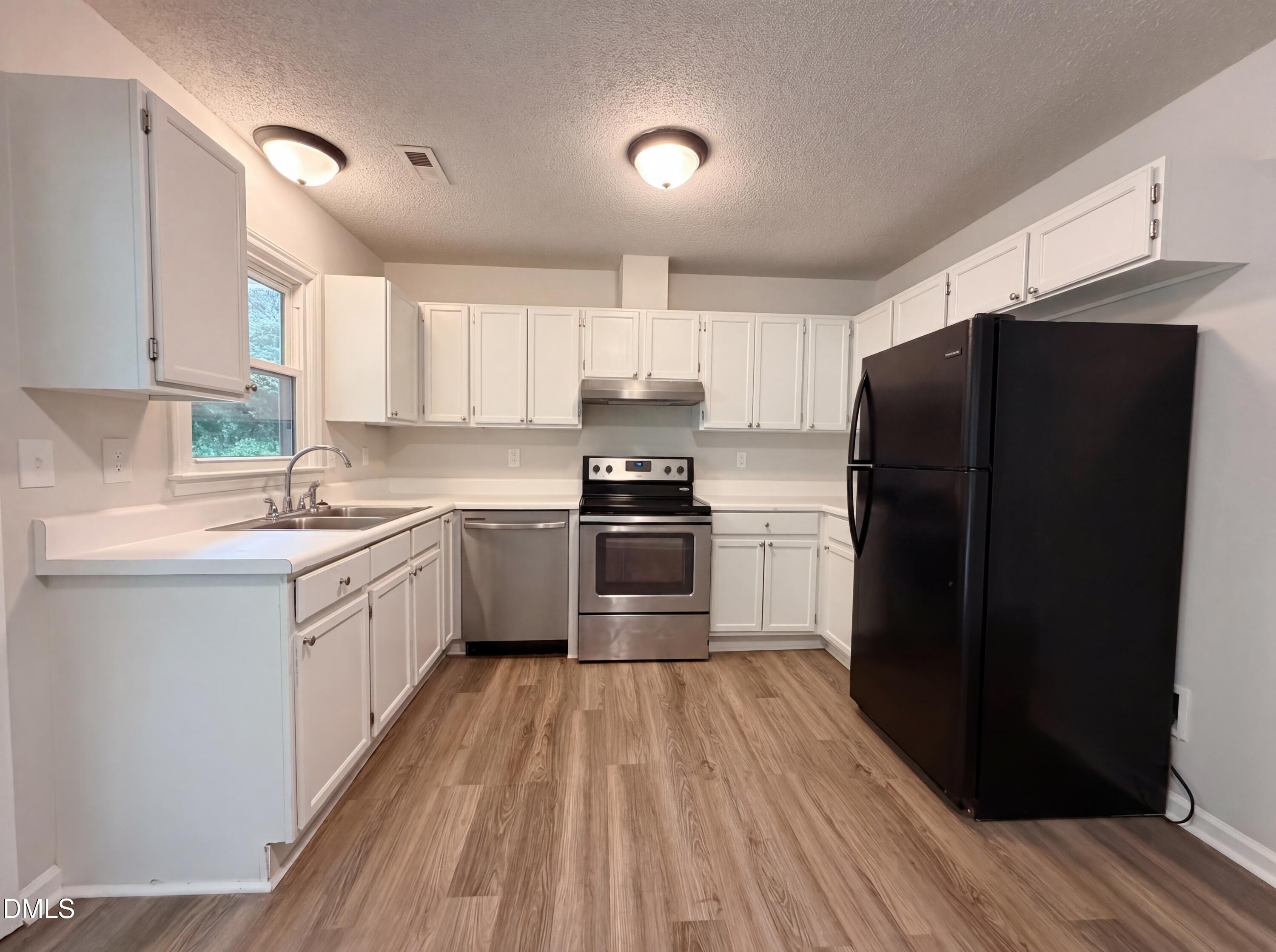 4894 Elevation Road, Unit C Benson, NC 27504 - Photo 9 of 24 a kitchen with granite countertop a refrigerator stove top oven and sink