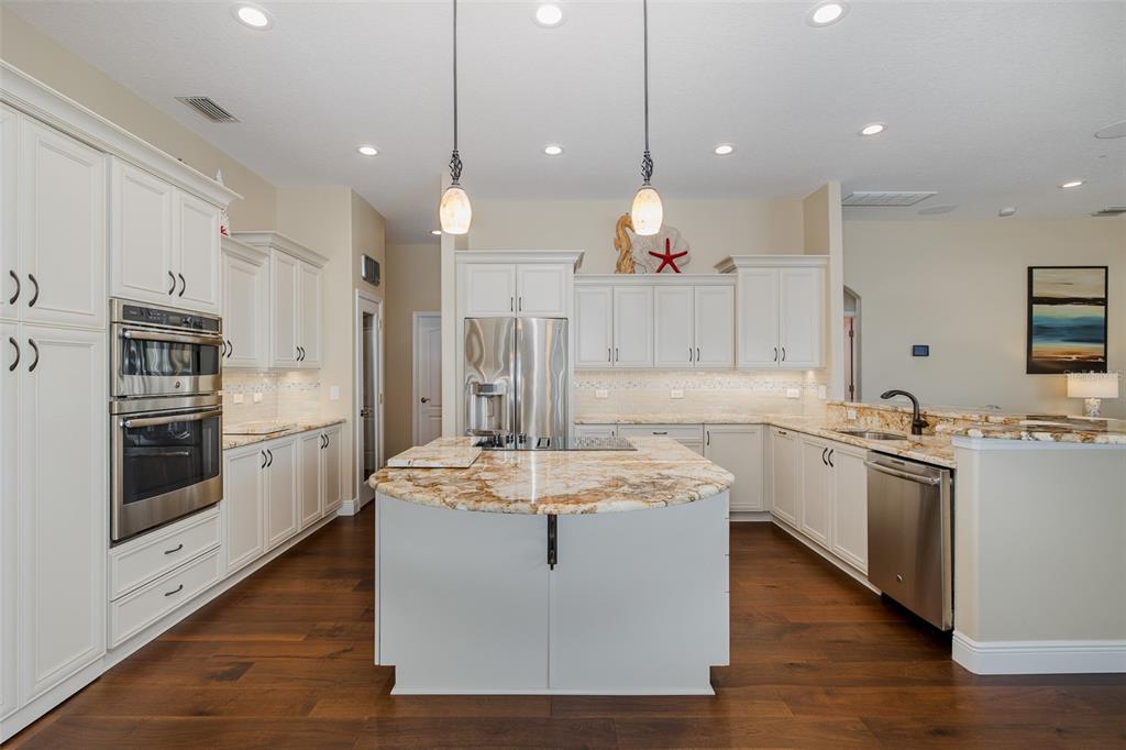 2928 Waters Edge Road Palm Harbor, FL 34685 - Photo 17 of 52 a large kitchen with stainless steel appliances granite countertop a stove a sink a oven and a refrigerator with kitchen island
