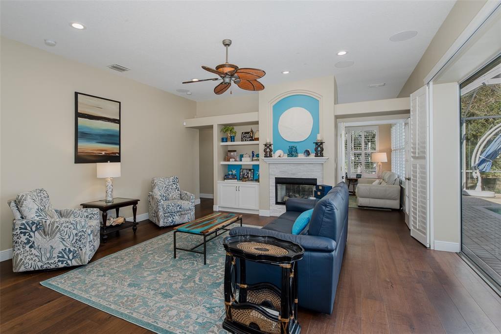 2928 Waters Edge Road Palm Harbor, FL 34685 - Photo 23 of 52 a living room with fireplace furniture and a wooden floor