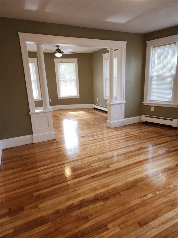 63 Fifth Avenue, Unit 1 Worcester, MA 01607 - Photo 5 of 13 an empty room with wooden floor and windows