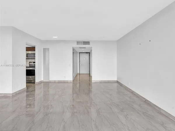 a view of a hallway with kitchen and entryway