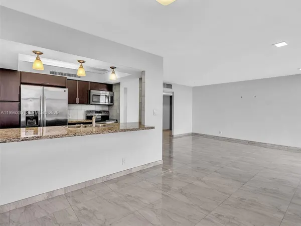 a view of kitchen with stainless steel appliances granite countertop a stove and a sink