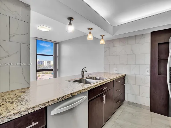 a kitchen with granite countertop a sink and stainless steel appliances